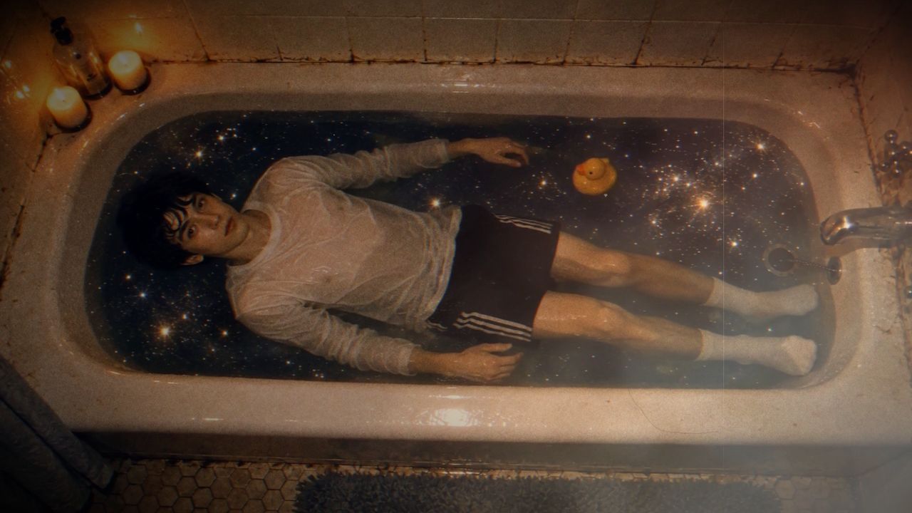 Lou floating in a bathtub full of stars, with a rubber duck.